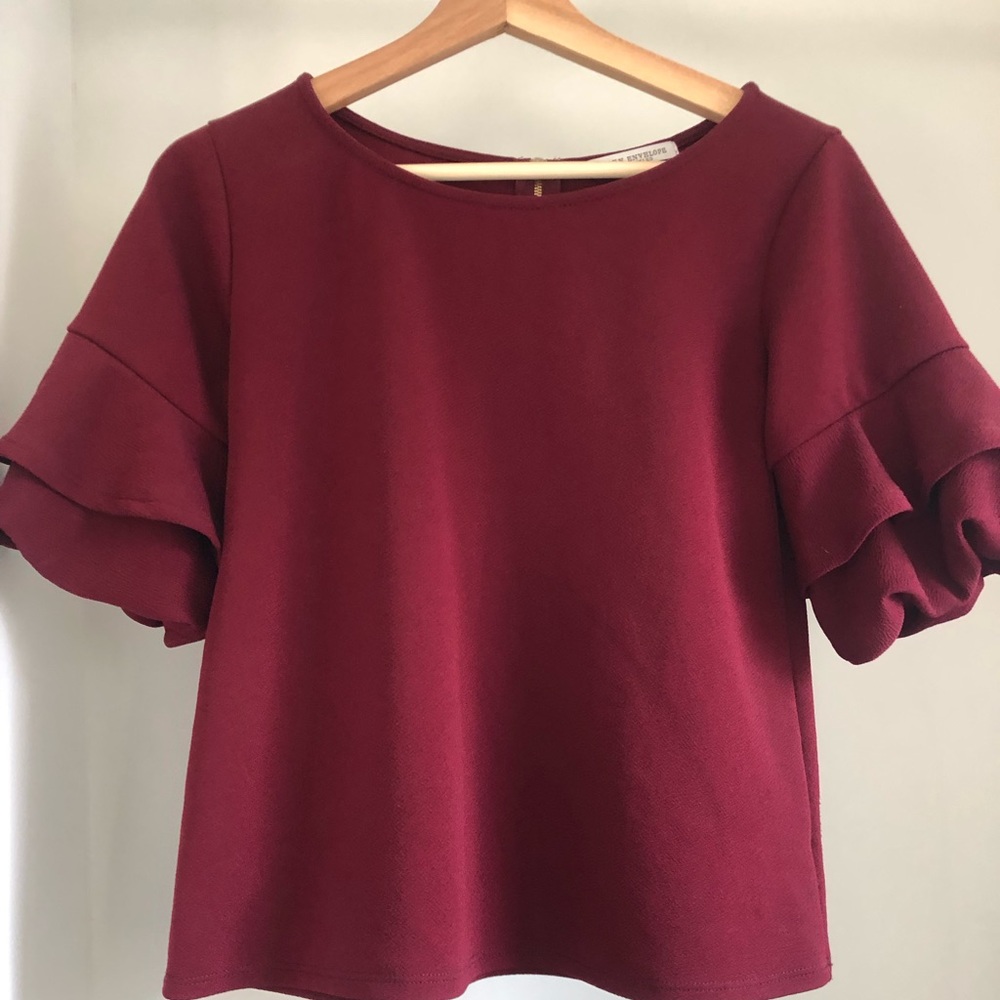 No filters. Cranberry colored blouse with a contrasting gold zipper.